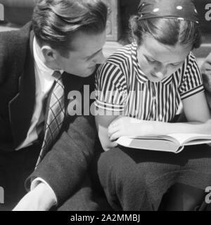 Ein Mann und eine Frau lesen ein Buch, Deutschland 1930er Jahre. Un uomo e una donna la lettura di un libro, Germania 1930s. Foto Stock