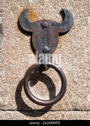 Bull a forma di testa di cavallo anello di cravatta fatta di ferro su una parete di granito Foto Stock