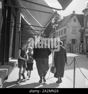 Frauen und Kinder in einer Einkaufsstraße in einer Kleinstadt in Deutschland, 1930er Jahre. Le donne e i bambini e la strada dello shopping in una città in Germania, 1930s. Foto Stock