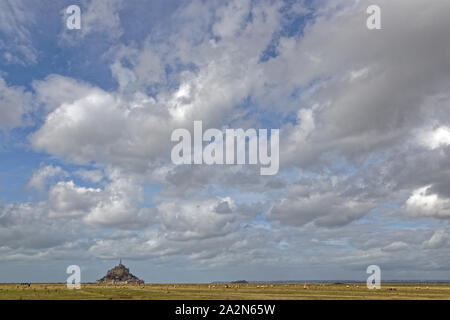 Paesaggio di campo e abbey. Uno dei più riconoscibili monumenti francesi, visitato da 3 milioni di persone all'anno, Mont Saint Michel e la sua baia sono su lis Foto Stock