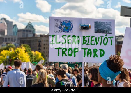 Montreal, CA - 27 Settembre 2019: Donna tenendo un 'presto troppo tardi' firmare in francese, al clima di Montreal marzo. Foto Stock