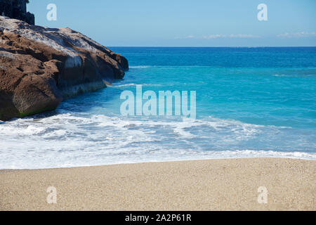 Mattina di sole con turchese blu e spumoso onde, tranquilla spiaggia vuota a Playa del Duque, Costa Adeje, Tenerife, Isole Canarie, Spagna Foto Stock