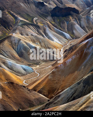 Fiume lungo una valle Landmannalaugar tra montagne colorate, Islanda Foto Stock