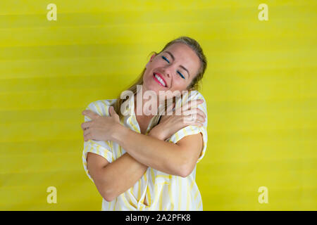 Bello e giovane donna europea su sfondo isolato abbracciando stessa, felice e positivo, la stima di sé - foto Foto Stock