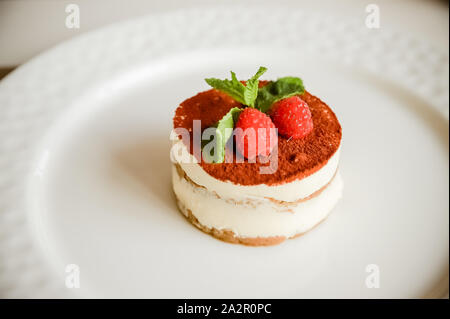 Il tiramisù - Classica Dessert con cannella e caffè. Guarnito con fragola e menta Foto Stock