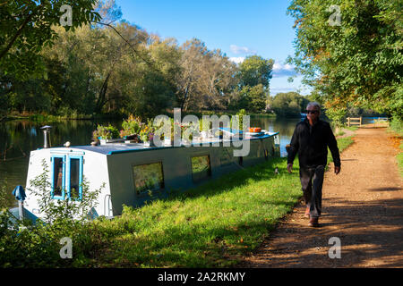 Uomo a camminare lungo il Tamigi percorso su un pomeriggio autunnale accanto al Fiume Tamigi a Sonning on Thames, Berkshire, Inghilterra, Regno Unito Foto Stock