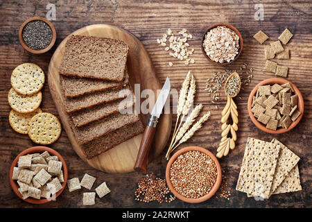 Ad alto contenuto di fibre alimentari di salute concetto con cereali integrali pane di segale, seminati i cracker, cereali, grano saraceno, fiocchi d'orzo e semi. Foto Stock