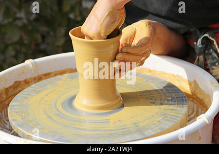 Mani formando una tazza su una ruota di vasai Foto Stock