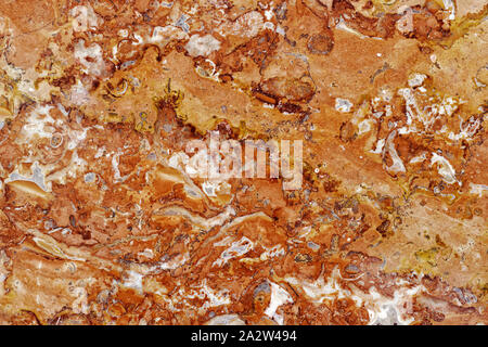 Gli sfondi e texture: superficie di un bel colore arancione decorativi in pietra, configurazione astratta di crepe, macchie e macchie e sfondo naturale Foto Stock