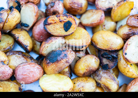 Grigliare piccole patate con fettine di aglio su una piscina grill a gas. Foto Stock