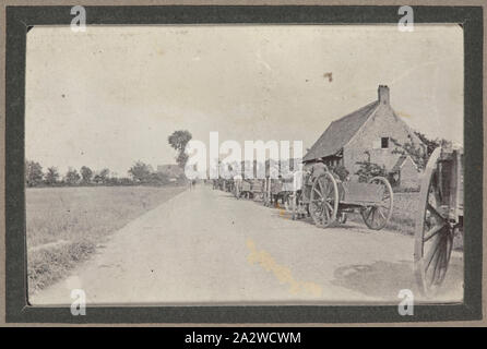 Fotografia - carrelli A cavalli nel villaggio francese, Francia, sergente John Lord, guerra mondiale I, 1916-1917, stampa fotografica in bianco e nero che raffigura una lunga linea di carrelli A cavalli di procedere attraverso un villaggio francese. La didascalia delle fotografie di 'treno' indica il cavallo e carri erano pieni di forniture generali come cibo, acqua e vestiti. È anche possibile che il cavallo di carretti tirati rappresentati erano parte di un campo ambulanza. Ogni campo ambulanza costituiti generalmente da 23 carri Foto Stock