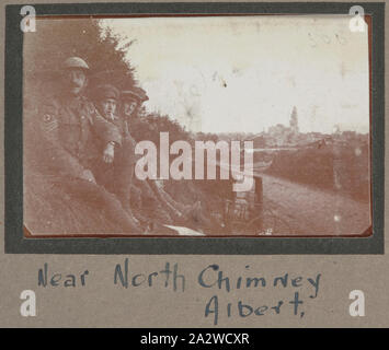 Fotografia - 'vicino al camino del Nord, Albert', Francia, sergente John Lord, guerra mondiale I, 1916-1917, stampa fotografica in bianco e nero che mostra quattro soldati seduti su una piccola collinetta erbosa con la città di Albert in background. Capi di abbigliamento di questi quattro soldati sono indossando indica che essi sono parte del campo ambulanza e molto probabilmente in base all'Albert. La sede centrale della divisione australiana è stata temporaneamente in base all'Albert a causa dei pesanti combattimenti che hanno avuto luogo nelle vicinanze Foto Stock