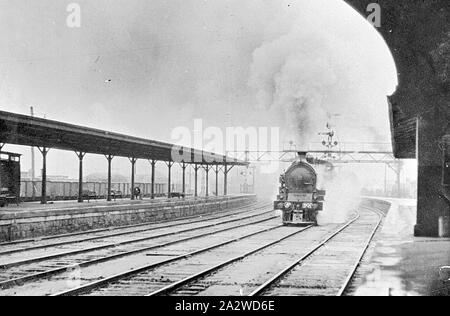 Negativo - A2-classe locomotiva a vapore No.901 viaggiando attraverso Ballarat Stazione Ferroviaria Victoria, circa 1925, A2-classe locomotiva a vapore No.901 viaggiando attraverso Ballarat stazione ferroviaria. I banchi sono visibili sulla pista coperta e un segnale può essere visto dietro la locomotiva. Alcune merci camion può essere visto parcheggiato in background Foto Stock