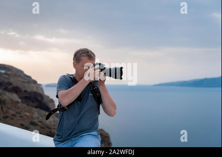 Fotografo traveler prende foto e della caldera di Santorini isola nel mare Egeo, Grecia Foto Stock