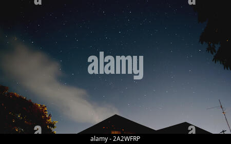 Notte Vista dal cielo con le stelle. Bassa angolazione. Casa tetto triangolare. Foto Stock