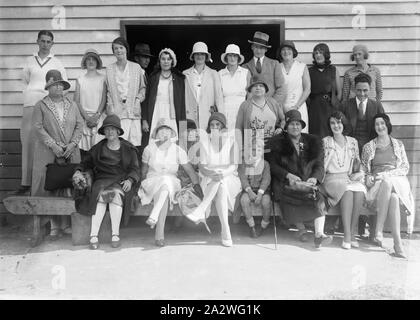 Negativo di vetro - Ritratto di gruppo in campo sportivo, circa 1930, una in bianco e nero, metà piastra negativa con un ritratto di gruppo di uomini, donne e bambini su un campo sportivo di fronte a un capannone di sport. Questi sono probabilmente i familiari e gli amici dei bambini che partecipano al visto gare su disegni di negativi Foto Stock