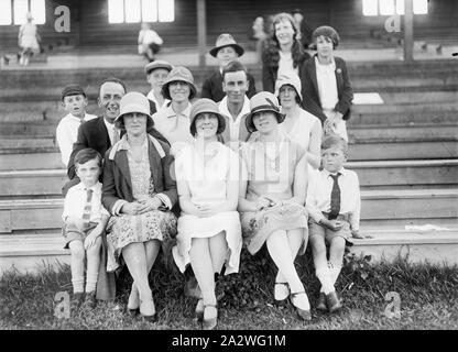 Negativo di vetro - Ritratto di gruppo in sport Stand, circa 1930, una in bianco e nero, metà piastra negativa con un ritratto di gruppo di uomini, donne e bambini in uno sport stand. Questi sono probabilmente i familiari e gli amici dei bambini che partecipano al visto gare su disegni di negativi Foto Stock