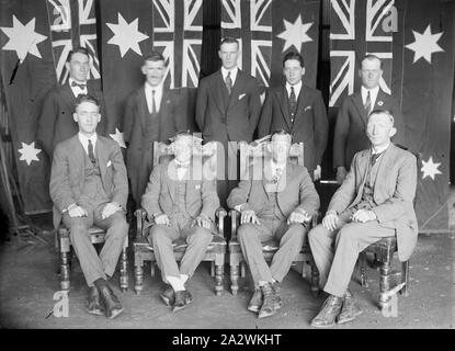 Vetro negativo - Maschio Ritratto di gruppo con bandiere, circa 1930, una in bianco e nero, metà piastra negativa con un ritratto di gruppo di uomini in abiti contro uno sfondo di ciò che sembrano essere Australian flag. Gli uomini sono posizionati in due righe, con due uomini in centro seduto in alte sedie e un altro due seduti in sedie regolari.La provenienza di questa immagine non è chiara, ma è venuto da Kodak museo aziendale a Coburg Foto Stock