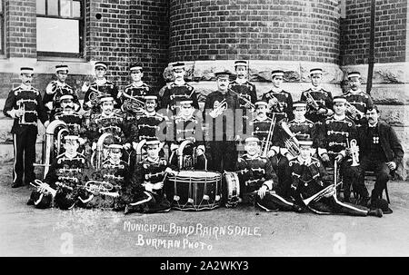 Negativo - Bairnsdale, Victoria, circa 1910, formalmente una fotografia di gruppo del Bairnsdale Banda comunale, posa con i loro strumenti musicali al di fuori di un edificio in mattoni. Tutti i membri della band sono in uniforme Foto Stock