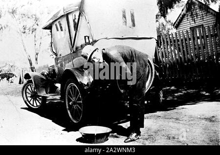 Negativo - Rheola, Victoria, 1930, un uomo lavando il suo modello T Ford auto in strada al di fuori di una casa Foto Stock