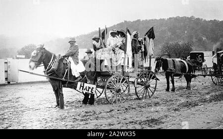 Negativo - Dipinto di gruppo sul carro, Eldorado, Victoria, Jan 1915, a cavallo il carro che porta un numero di persone che sembrano essere in faccia nera raffigurante gli aborigeni. Vi è un segno "odio" attaccati agli alberi, un segno sulla parte anteriore del carro " Il nostro motto aiutare gli Australiani' e una parzialmente oscurata segno sul lato del carrello che legge l'odio tirando queste"australiani Foto Stock