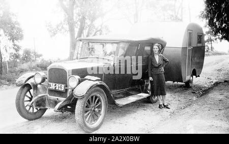 Negativo - Drouin, Victoria, 1938, una donna in piedi accanto a una partita di Rugby 6 motore cilindro di auto e un 'l' caravan Foto Stock