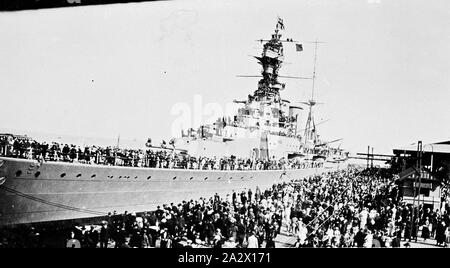 Negativo - Folla di ispezionare il dispositivo HMS cofano al Princes Pier, Port Melbourne, Victoria, Mar 1924, chiamato dopo il XVIII secolo l'Ammiraglio Samuel cofano, cappa di HMS è stata l'ultima battlecruiser costruita per la Royal Navy. Originariamente uno dei quattro Admiral-class battlecruisers ordinato in mid-1916, lei è stato uno solo essendo completato commissionato nel 1920 Dopo estese modifiche comprato circa da una revisione della battaglia dello Jutland, che ha mostrato seri limiti nel design originale. Sul lancio Foto Stock