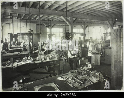 Fotografia - Hecla Electrics Pty Ltd, il Gruppo Lavoratori, 1920s, fotografia di maschi dipendenti Hecla assembing prodotti elettrici, eventualmente a Hecla's Little Bourke Street locali a Melbourne. A sinistra dell'immagine completata parzialmente bollitori e riscaldatori elettrici sono visibili. A destra sono pezzi di lamiera ornamentali includente una sfinge alato e la placca di metallo di nomi. Questo suggerisce una data anticipata per la fotografia, come Hecla spostato preogressively Foto Stock