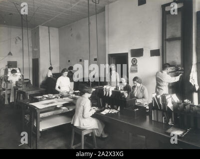 Fotografia, laboratorio di elaborazione, Perth, Western Australia, 1935, fotografia in bianco e nero della Kodak Australasia Pty Ltd processing lab, probabilmente in Hay Street, Perth. È dotato di area di lavoro con 7 donne e due uomini al lavoro. Le donne sono la giunzione e smistamento di fotografie e un uomo è il recupero di grandi fogli di prodotti da un essiccamento o appendere rack. Questa è una delle 3 fotografie delle strutture di Perth, stampati a illustrazioni Ltd, 870 hay Street Perth Foto Stock