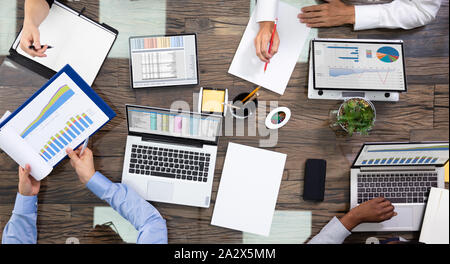 Elevato angolo di visione di un team di dirigenti aziendali discutendo sui dati in Sala Riunioni Foto Stock