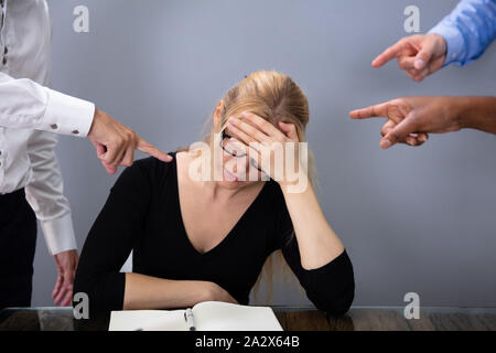 La gente di affari le mani puntando al sottolineato imprenditrice appoggiato sulla scrivania in ufficio Foto Stock