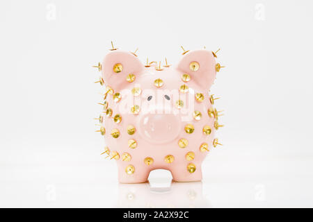 Immagine concettuale che illustra la protezione dei risparmi e degli investimenti che mostra una banca rosa piggy protetta da tacchi di disegno e isolata contro il bianco. Foto Stock