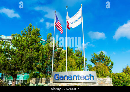 Genentech firmare con la bandiera degli Stati Uniti, Bandiera della California e Genentech bandiera sventolare nel vento Foto Stock