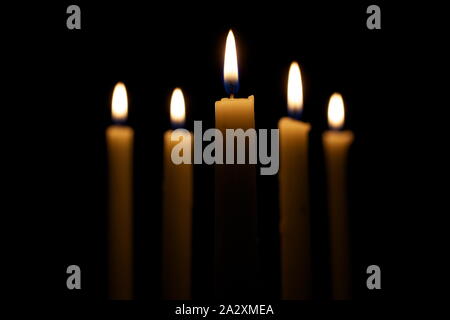 Cinque candele accese nelle tenebre. Foto Stock