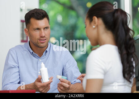 Mostra al cliente femmina una soluzione per lenti a contatto Foto Stock