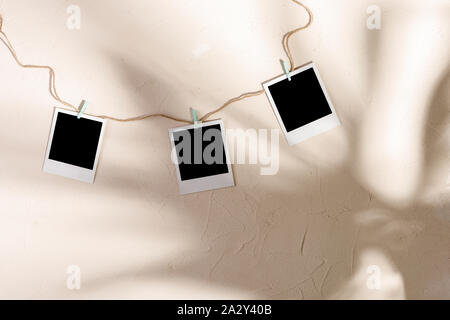 Blank Foto appendere con clothespins su un tessiturali sfondo. Copia dello spazio. Foto Stock
