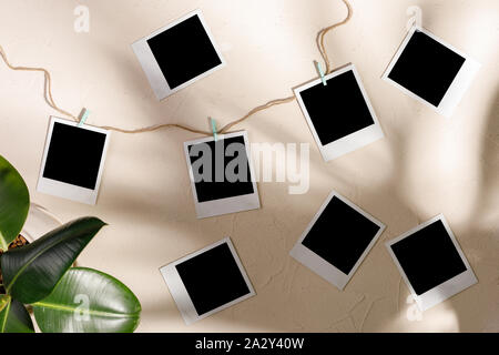 Blank Foto appendere con clothespins su un tessiturali sfondo. Copia dello spazio. Foto Stock