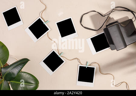 Foto di vuoto e di una fotocamera con clothespins su un tessiturali sfondo. Il concetto di conservazione di memorie. Copia dello spazio. Foto Stock