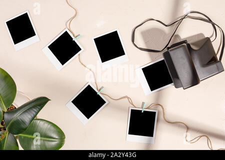 Foto di vuoto e di una fotocamera con clothespins su un tessiturali sfondo. Il concetto di conservazione di memorie. Copia dello spazio. Foto Stock