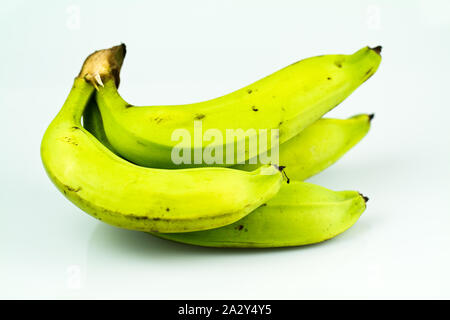 Banane verdi sul tavolo bianco close up shot Foto Stock