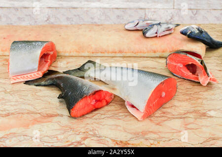 Pezzi di tagliare il salmone fresco pesci giacente sulla tavola di marmo Foto Stock