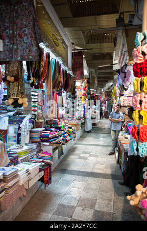 Varietà di tappeti tradizionali e abbigliamento per la vendita su il souk di Mascate e Oman Foto Stock