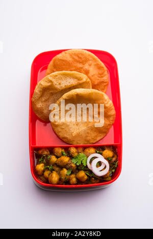 Punjabi Chole / Choley masala con puri o poori nella scatola di pranzo o ristorante Tiffin, il fuoco selettivo Foto Stock