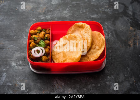 Punjabi Chole / Choley masala con puri o poori nella scatola di pranzo o ristorante Tiffin, il fuoco selettivo Foto Stock