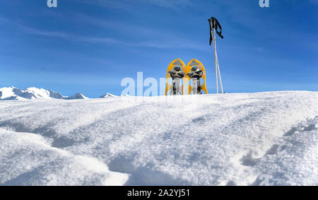 Le racchette da neve nella neve sulla cima del monte sotto il cielo blu Foto Stock