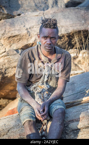 Il lago Eyasi, Tanzania, 11 Settembre 2019: Hadzabe uomo appoggiato con il suo arco e frecce Foto Stock