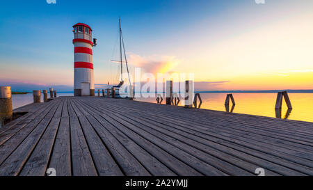 Faro di lago di Neusiedl, Podersdorf am See, Burgenland, Austria. Faro al tramonto in Austria. Il molo di legno con il faro in Podersdorf sul lak Foto Stock