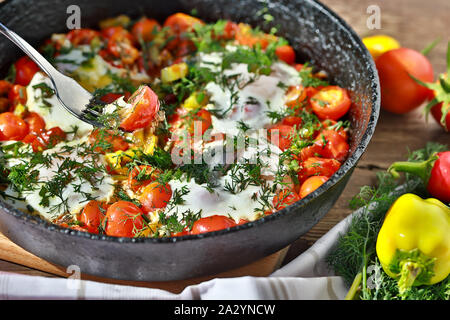 Uova fritte con le verdure in una padella, colazione vegetariana Foto Stock