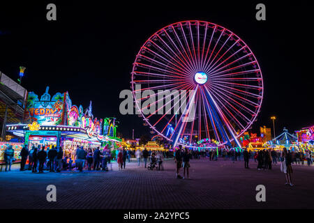 Stoccarda, Germania, 3 ottobre 2019, molte persone godono colorate ruota di grandi dimensioni e offre cibo a canstatter wasen oktoberfest festival folk di notte Foto Stock