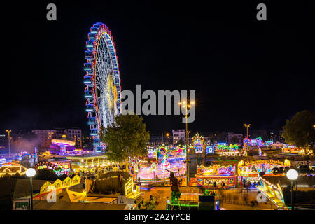 Stoccarda, Germania, 3 ottobre 2019, Canstatter wasen oktoberfest folk festival illuminando la notte con molti giostra ruota grande e offre cibo b Foto Stock